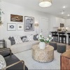 living room in the model with a couch and view of the kitchen 