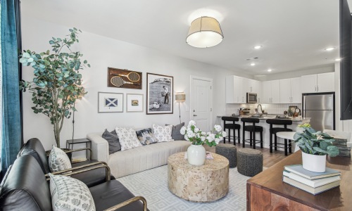 The essence of exceptional living living room in the model with a couch and view of the kitchen
